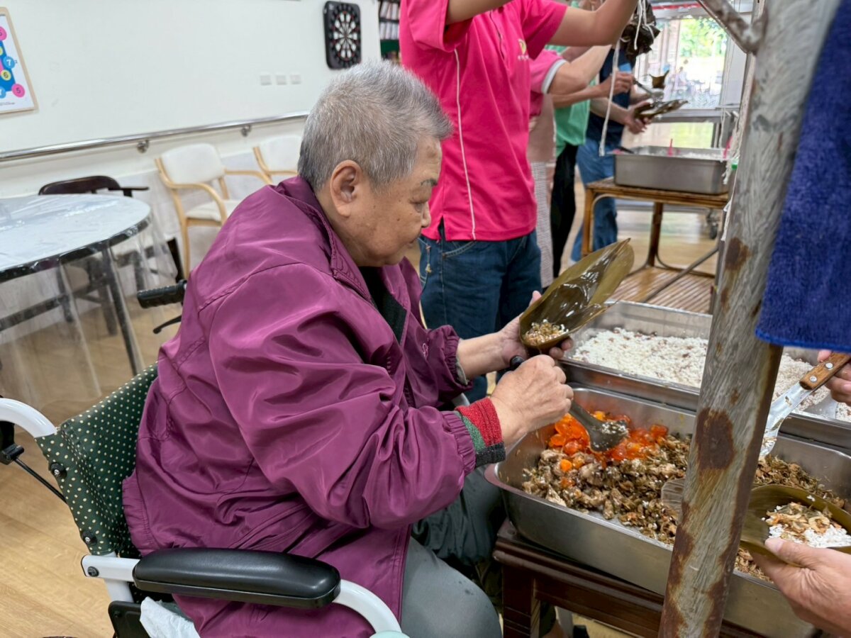 83歲徐阿嬤在照顧團隊協助後拔除鼻胃管，端午節開心包粽吃粽子。(圖片來源/椰子園)