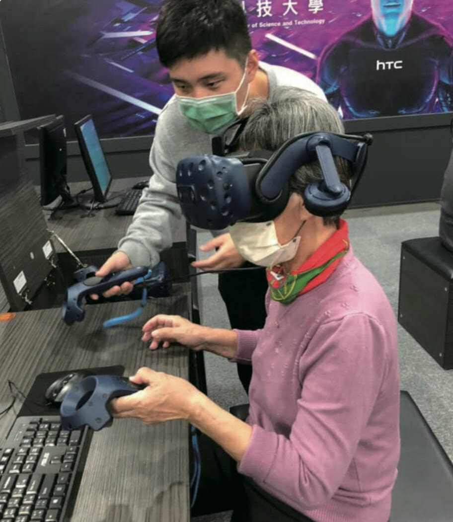 資訊管理系的學生帶領長輩體驗VR虛擬實境科技，刺激長者感官刺激。(圖片來源/謙和賀日照中心)
