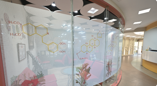 美康總部內，一面牆上畫著許多藥材與化學式，最左邊的圖像為海洛因，代表企業內個 性積極但急躁的夥伴，需要如甘草一般個性圓滑的人協助意見調節。(攝影/劉國泰)