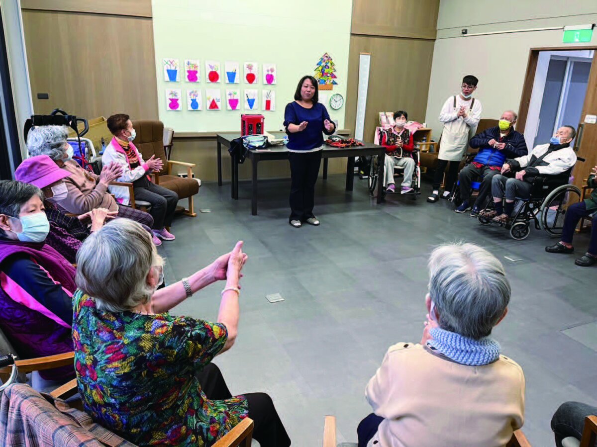 長輩隨著加賀谷宮本式音樂療法，搭配動作，訓練日常生活的活動。(攝影/林宏洲)