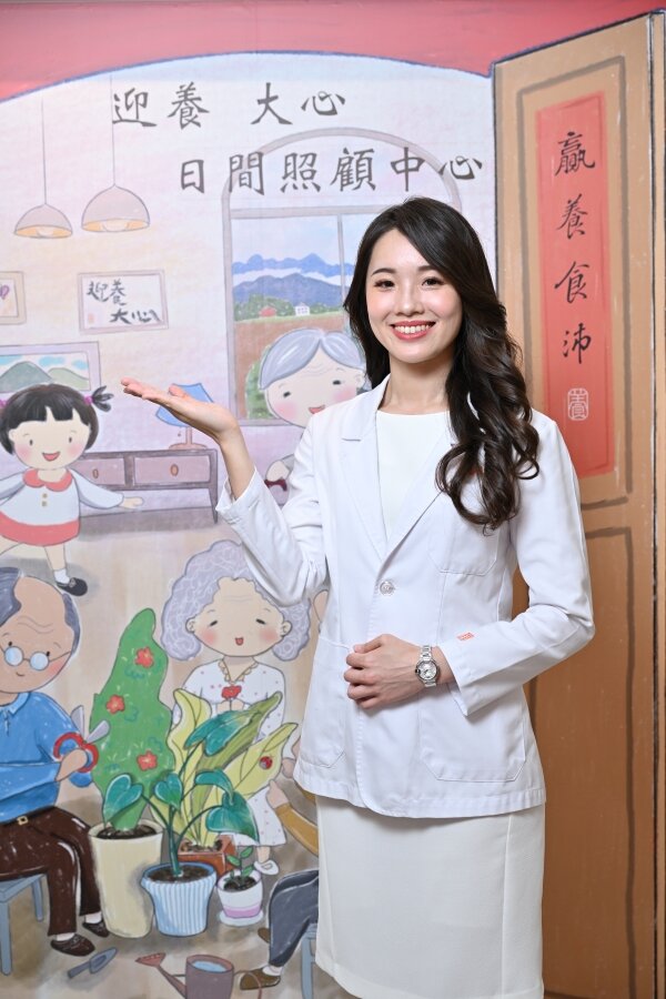 許睿慈創辦大心與迎養日照中心，背後牆上的插畫就是描繪他童年的模樣。