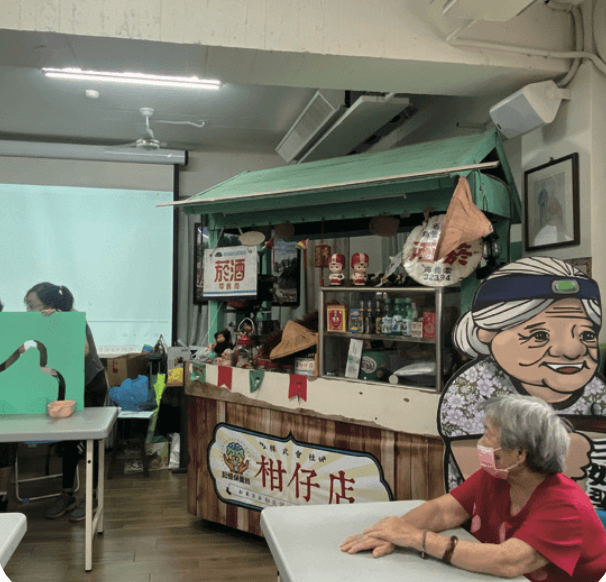 彰化基督教醫院人員為失智長輩上課，庚新診所也規劃如發放籌碼玩遊戲，可到據點的「柑仔店」兌換商品。（圖片來源／王雪玲）