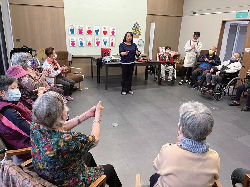長輩隨著加賀谷宮本式音樂療法，搭配動作，訓練日常生活的活動。(攝影/林宏洲)