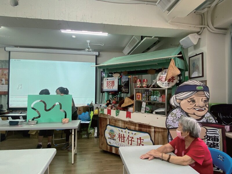 彰化基督教醫院人員為失智長輩上課，庚新診所也規劃如發放籌碼玩遊戲，可到據點的「柑仔店」兌換商品。（圖片來源／王雪玲）